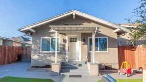 A single-story house with a front porch, a small front yard, and a wooden fence. - Central 3-bedroom House with a Yard and Free Parking, Near Downtown (San Diego)