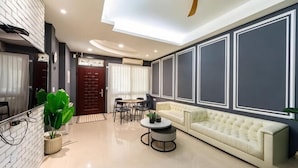 A modern living room with a sofa, coffee table, and a dining area with chairs. - Senshe B&B (Taitung)