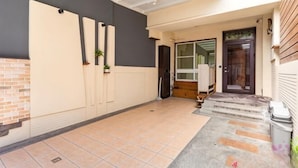 A hallway with a tiled floor, a door, and a window. - Senshe B&B (Taitung)