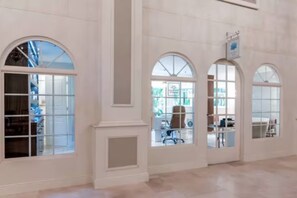 A spacious interior with large arched windows, a high ceiling, and a clean, minimalist design. - Pool/Steps to beach/dining1br (Palm Beach)