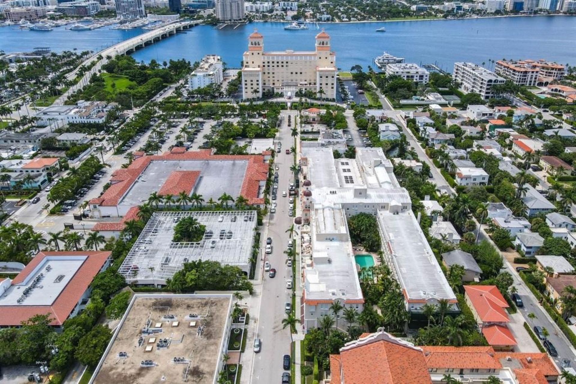 An aerial view of a coastal city with a prominent historic building, a marina, and residential areas.