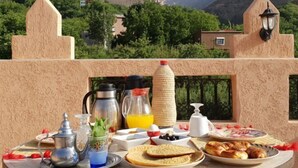 Un coin petit-déjeuner aménagé avec vue sur les montagnes et la verdure.