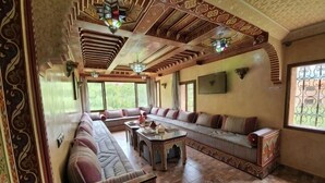 Une pièce spacieuse avec un long canapé, une petite table et un plafond décoratif.