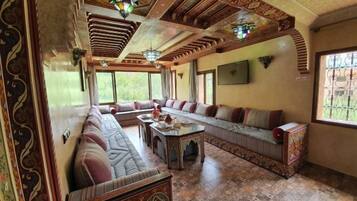 Una habitación tradicional con un sofá grande, una mesita y un televisor.