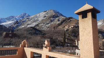 A mountain landscape with a clear sky, a stone tower, and a fence.