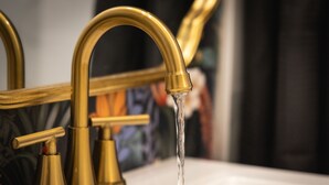 A gold faucet with water running into a white sink. - Tahoe Mountain Inn #34 (SOUTH LAKE TAHOE)