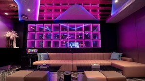 A modern lounge with a sectional sofa, a coffee table, and a wall unit with shelves. - I Will Motel (Hsinchu County)