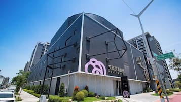 A modern building with a unique geometric design, featuring a prominent logo on the facade.