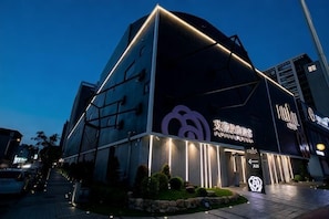 A modern building with a prominent logo and signage indicating a hotel or similar establishment. - I Will Motel (Hsinchu County)