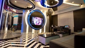 A modern living room with a large TV, circular light fixtures, and a patterned floor. - I Will Motel (Hsinchu County)