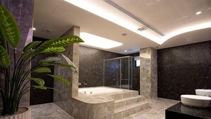 A modern bathroom with a large bathtub, a glass shower enclosure, and a potted plant. - I Will Motel (Hsinchu County)
