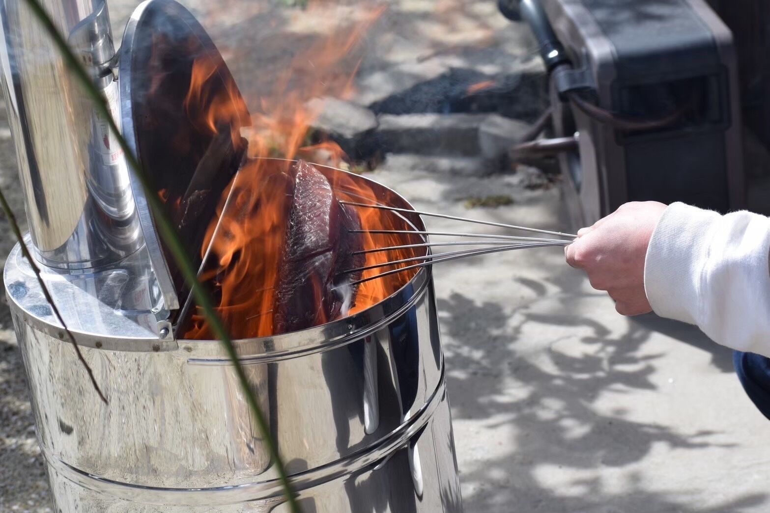 En person som grillar kött över öppen eld.