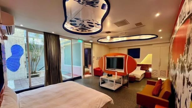 A modern hotel room with a large bed, a TV, a sofa, and a dining area. - No9 Hotel (Changhua)
