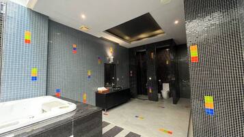 A modern bathroom with a bathtub, a vanity, and a shower area.
