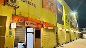 A row of closed shops with signage in a foreign language, a tiled wall, and a brick building facade. - No9 Hotel (Changhua)