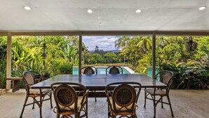 An outdoor covered dining area with a view of a pool and lush greenery. - Dog Friendly Retreat with Pool & Stunning Hinterland Views (Ninderry)