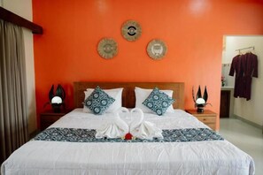 Una habitación de hotel con una cama, una mesita de noche y una pared decorada con platos.