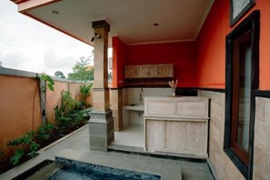A kitchen with a wooden cabinet, a sink, and a window. - Moning Villa Ubud (Bali)
