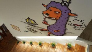 A wall with a cartoon character, a sailboat, and a dog illustration. - Mr.Rabbit (Pingtung)