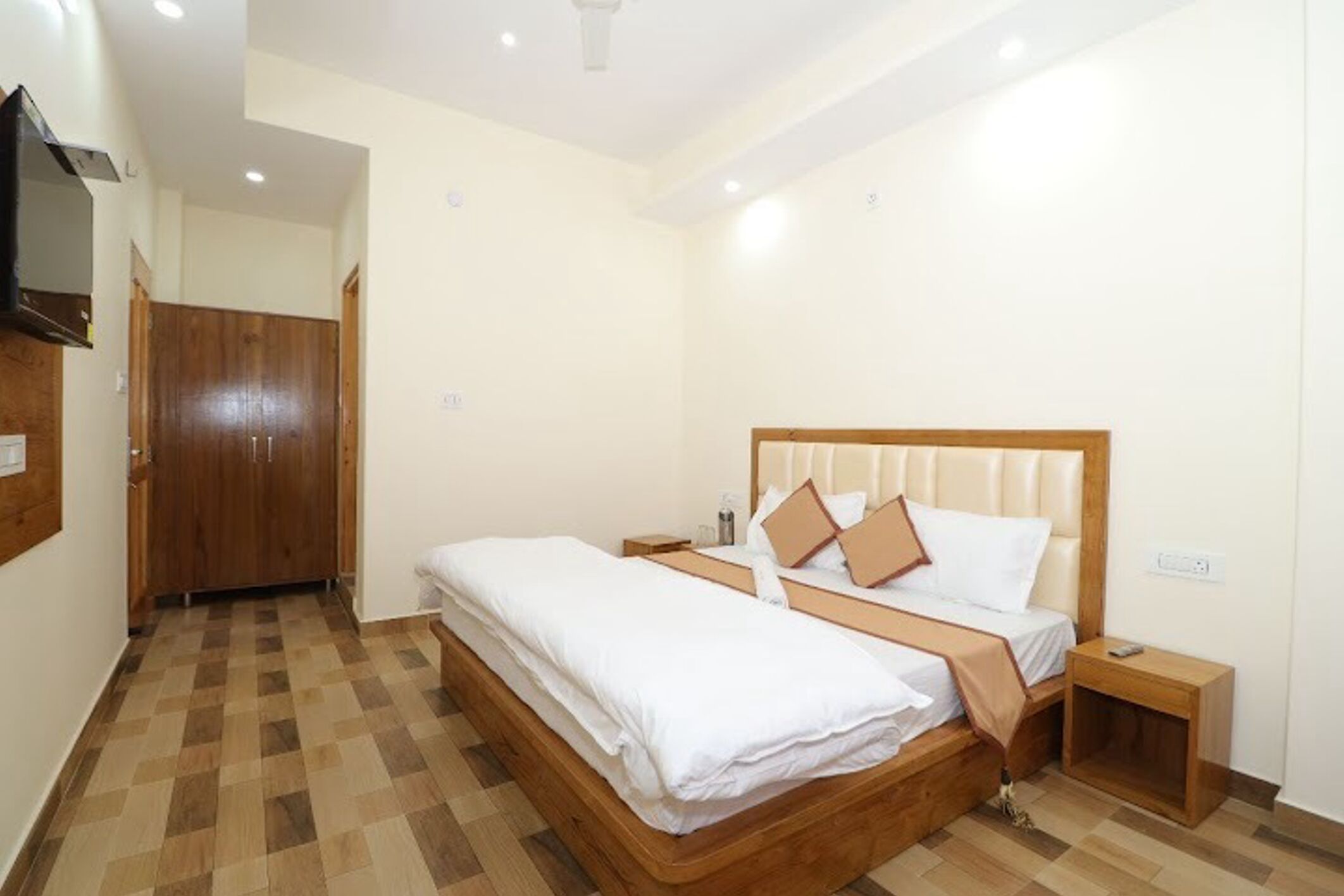 Een slaapkamer met een houten bed, nachtkastje en een garderobe.