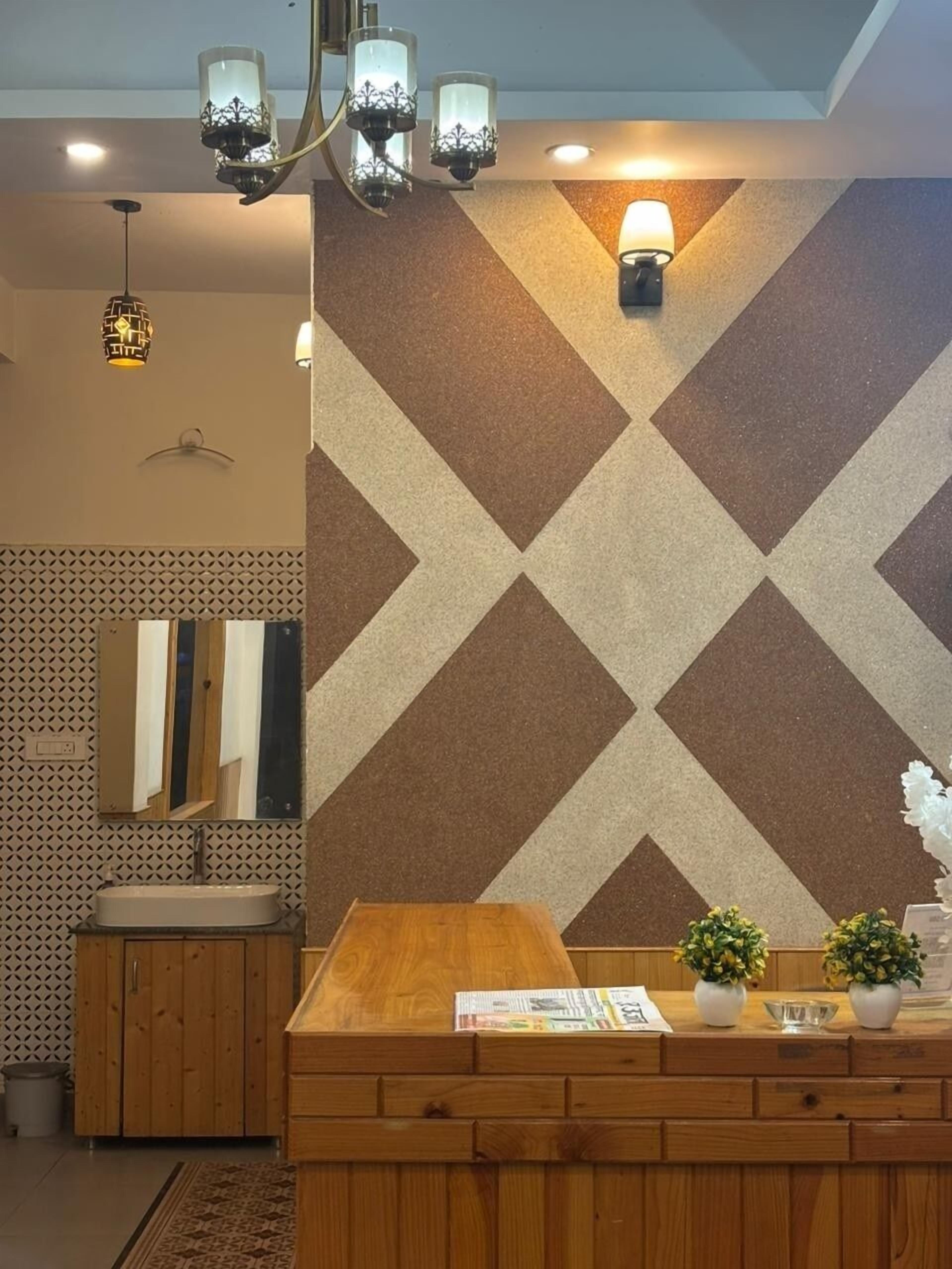 Un baño con tocador de madera, un espejo y un papel tapiz estampado.