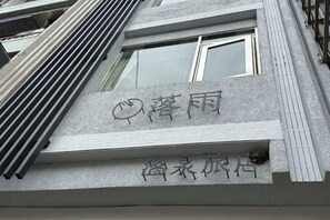 A building facade with a sign that reads 'Lush Rain' and 'Erqi Hotel'.