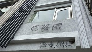 Een gevel met een bord waarop "Xiangfu" en "Xiangfu Hotel" staat.