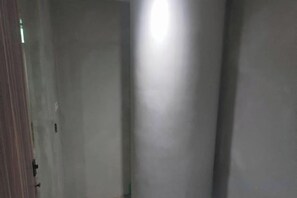 A corridor with a door on the left and a light source on the right. - Happiness meworld (Taipei)