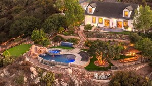 A large house with a swimming pool, outdoor seating, and a well-maintained garden. - San Diego Serenity Hills, Pickleball, Golf, Infinity Pool with Epic Views (Jamul)
