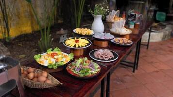A table with various food items and a basket of eggs.