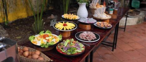 A table with various food items and a basket of eggs.