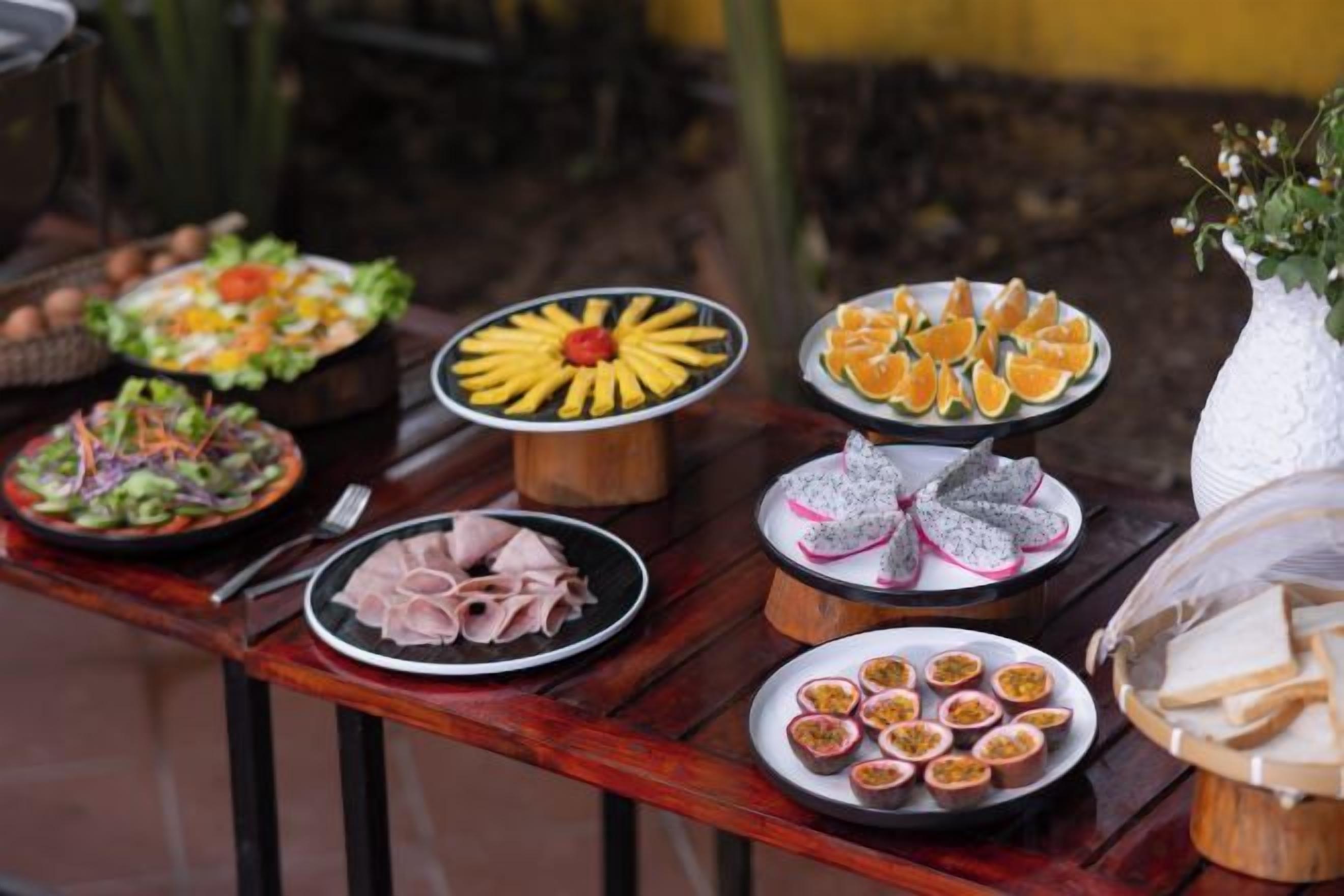 A table with various food items including salads, fruits, and pastries.