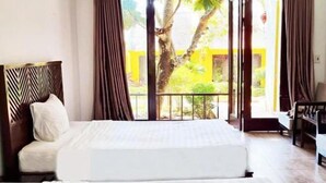 A hotel room with a bed, curtains, a view of the outdoors, and a balcony. - Hoi An Phu Quoc Resort & Spa (Phu Quoc Island)