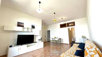 Appartamento Deluxe, vista mare | Area soggiorno | TV a schermo piatto 36 pollici con canali digitali