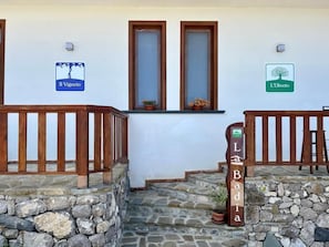 A stone staircase leading to a wooden door with a sign reading "La Badia." - La Badia (Vico Equense)