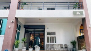 A building entrance with a double door, potted plants, and outdoor seating. - Ching-shan Inn (Pingtung)