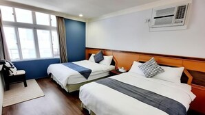 A hotel room with two beds, a desk, and a chair. - Ching-shan Inn (Pingtung)