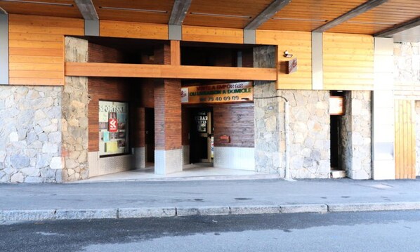 Un edificio con fachada de piedra, vigas de madera y un letrero que anuncia una tienda deportiva.