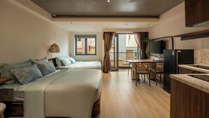 A modern bedroom with a large bed, a small desk, and a kitchen area with a refrigerator and a TV. - Lune Boutique Hotel & Apartment Da nang (Da Nang)