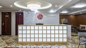 A reception desk with a marble column, a chandelier, and a sign for EDOYA HOTEL. - Edoya Hotel Phu My Hung (Ho Chi Minh City)