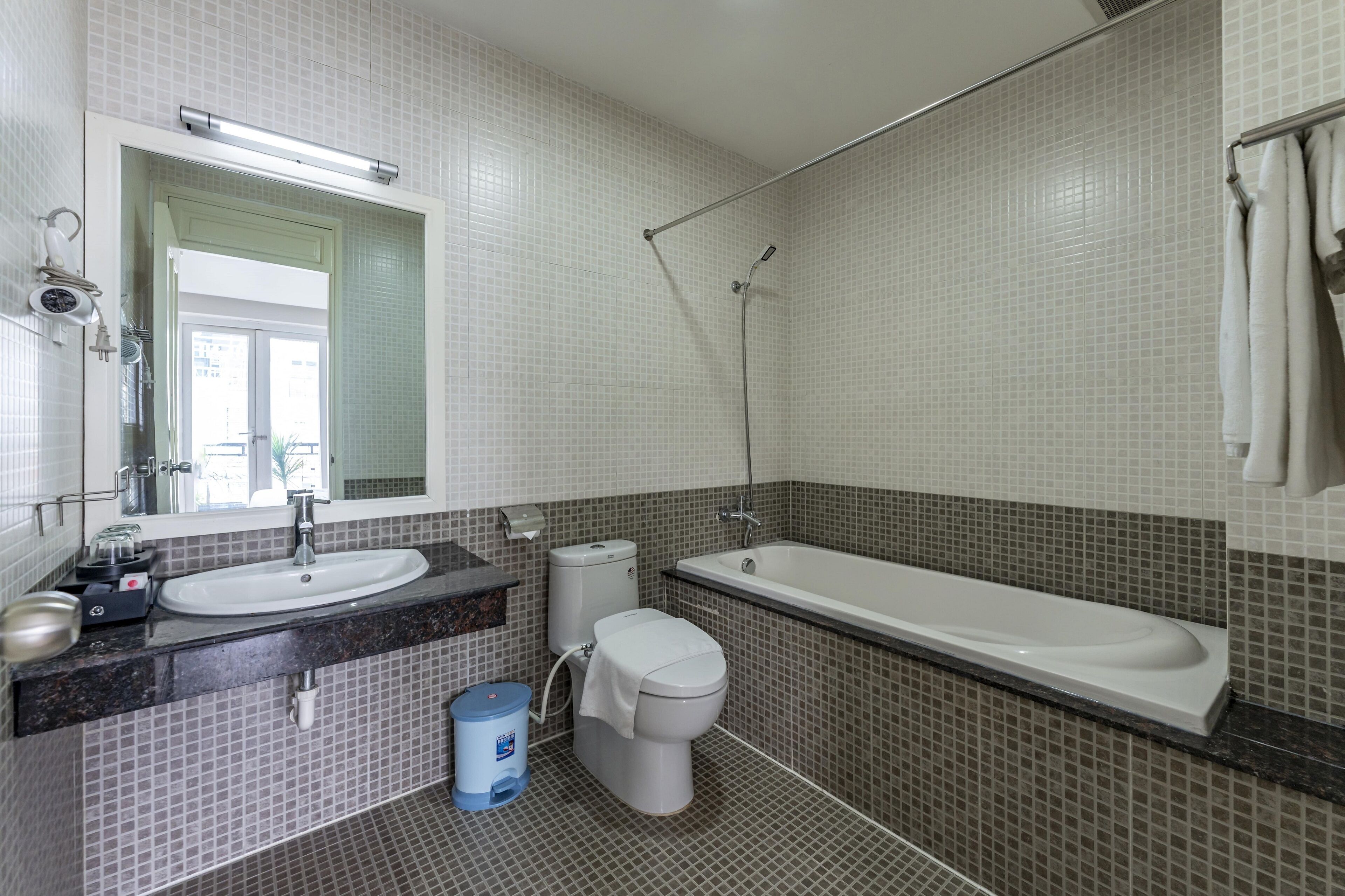 A modern bathroom with a sink, toilet, and bathtub.