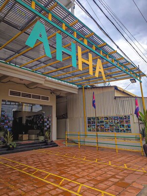 A building with a large sign reading 'AHHA' and a display of photos on the side.