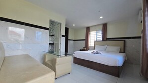 A hotel room with a bed, a glass table, a chair, and a nightstand. - AHHA Residence Kampot (Kampot)