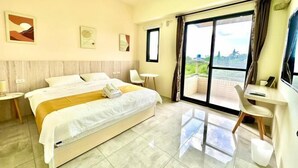 Une chambre d’hôtel avec un lit, un bureau, une chaise, une télévision et un balcon avec vue.