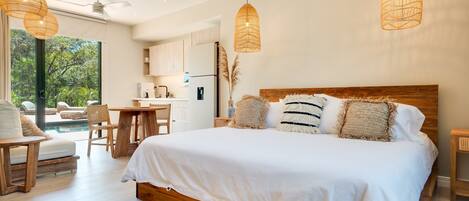 A bedroom with a large bed, wooden headboard, and two hanging wicker lamps.