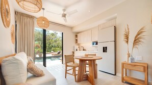 A modern kitchen with a dining area, wooden furniture, and a view of a pool. - The Bungalows-Flamingo (Playa Flamingo)