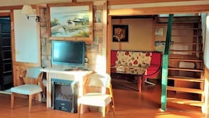 Una habitación acogedora con chimenea, televisión y estantería.