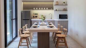 A modern kitchen with a central island, a dining area with six chairs, and a large window. - Tiansong Villa (Yilan)
