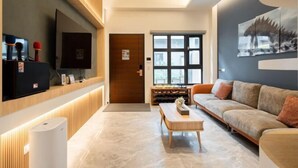 A modern living room with a sofa, a coffee table, a television, and a wine rack. - Tiansong Villa (Yilan)