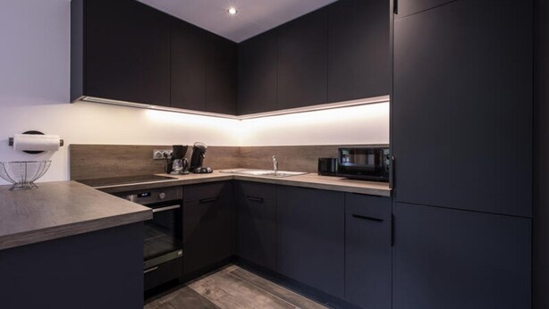 A modern kitchen with dark cabinetry, a microwave, a coffee maker, and a sink. - 3 Rooms for 4 People (Le Grand-Bornand)
